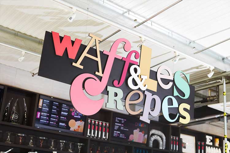 Waffles & Crepes signage hanging above shop counter